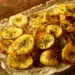 Golden Crispy Baked Green Banana Chips Dusted With Roasted Cumin And Dried Mint On Parchment And Rustic Wood